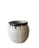 A beige and bronze ceramic utensil crock or vase on a white background. 