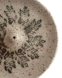 Close-up of a ceramic plate with leaf patterns
