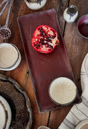 A table setting with trays, bowls and a pomegranate.