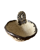 Ceramic ring dish with decorative lid on a white background