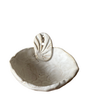 Ceramic seashell-shaped dish with a decorative top on a white background