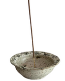 Ceramic incense holder with a single incense stick on a white background