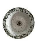 Ceramic plate with speckled design on a white background