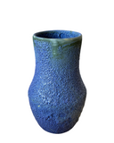 A ceramic vase with a textured, frothy, bubble-like surface in a rich blue based purple color.