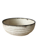 Beige ceramic bowl with black rim on a white background