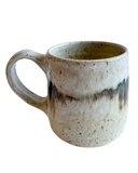 Ceramic mug with speckled pattern on a white background