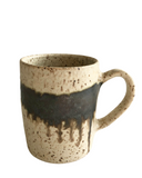 A collection of five ceramic mugs in various colors including beige, pink, gray, purple, and red, each with a rustic design.