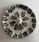 Decorative ceramic plate with black floral patterns on a white background