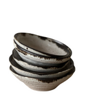 A stack of five round ceramic mini dip bowls with a speckled glaze in shades of gray and bronze.