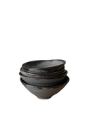 A stack of five round ceramic mini dip bowls with a speckled glaze in shades of gray and bronze.