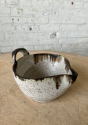 Mixing bowl on a kiln with a white brick backgrouond.