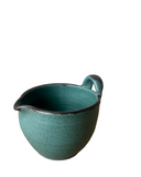 Teal ceramic pitcher on a white background