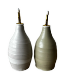 Two ceramic salt and pepper shakers with gold nozzles on a white background