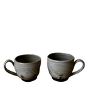 Gray and black mugs on white background