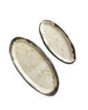 Two oval-shaped ceramic trays with a speckled beige and white glaze finish. One is small and the other is medium-sized.
