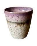 Speckled ceramic cup with purple rim on a white background