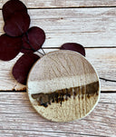 Round ceramic plate with textured surface on wooden background