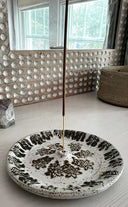 Decorative plate with floral patterns on a light-colored floor.
