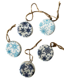 String of ceramic ornaments with blue snowflake patterns on a white background