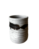 A collection of five handmade ceramic tumblers with various colored interiors.