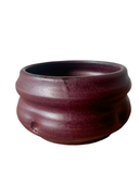 A collection of handcrafted brown stoneware flower pots with a matte glaze and bronze accents, displayed against a white background.