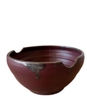 Burgundy red ceramic bowl on a white background