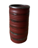 Red cylindrical ceramic vase with ribbed texture on a white background