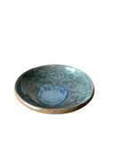Ceramic bowl with blue interior and patterned exterior on a white background