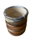 Ceramic pot with striped design on a white background