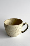 Speckled ceramic mug on a light gray background