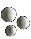 Three ceramic bowls with a textured surface on a white background