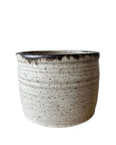 A beige and bronze ceramic utensil crock or vase on a white background. 