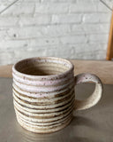 Speckled ceramic mug on a neutral background