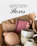 Mystery boxes with ceramic items and textured paper on a light background