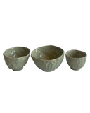 Three ceramic bowls with textured surfaces on a white background