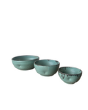 Three teal ceramic bowls of different sizes on a white background