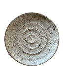 Speckled ceramic plate on a white background