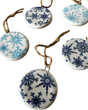 Decorative ceramic ornaments with blue snowflake patterns on a white background