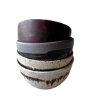 Set of four ceramic bowls in various colors on a white background