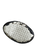 Black oval plate with textured white ceramic inside on a white background