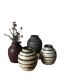 Set of four ceramic vases with different designs on a white background