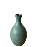 Green ceramic vase with speckled texture on a white background