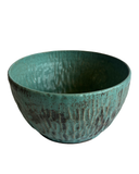 Teal ceramic bowl with textured surface on a white background