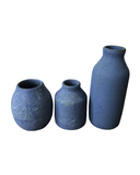 A ceramic vase with a textured, frothy, bubble-like surface in a rich blue based purple color.