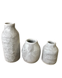 Three textured ceramic vases on a white background