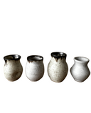 Set of four ceramic vases with textured finish on a white background