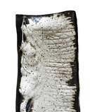 Close-up of a textured ceramic plate with black and white patterns