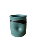 Teal ceramic cup with black accent on a white background