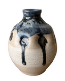 Ceramic vase with blue and black glaze on a white background