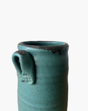 Teal ceramic mug with speckled texture on a white background